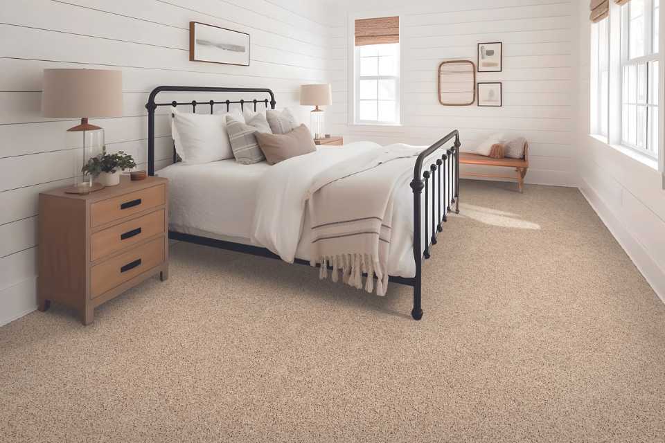 plush soft beige carpet in simple cabin bedroom with shiplap walls and wood accents